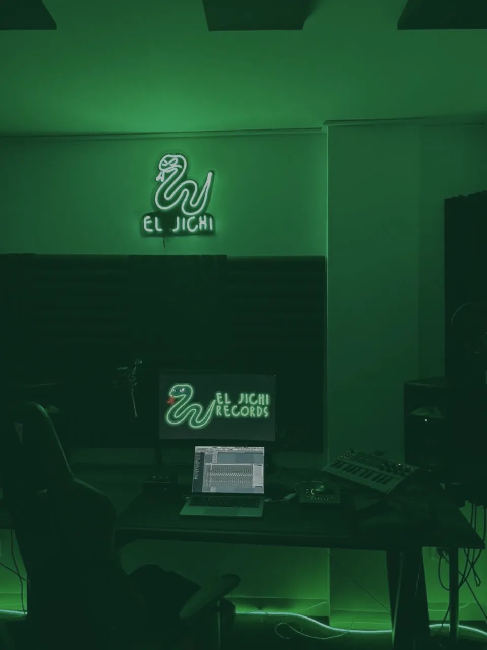 Mesa de producci&oacute;n de El Jichi Records con teclado MIDI, interfaz Apollo y monitores, en luz verde